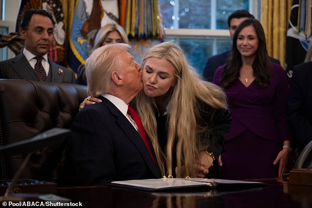 US President Donald Trump plants a kiss on the cheek of Erika, the widow of Right-wing activist and broadcaster Charlie Kirk