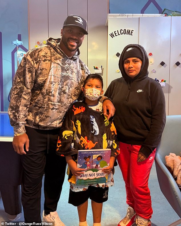 Russell Wilson, pictured at a children's hospital in New York on Tuesday, is now the team's QB3