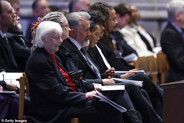 Judith Goodall sits with family members at her sister's funeral service