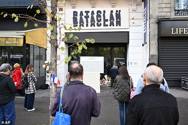 People pay their respects to victims in front of the Bataclan concert hall as Paris is marking the 10th anniversary of terrorist attacks that killed 132 people and injured hundreds on Thursday, November 13, 2025, in Paris