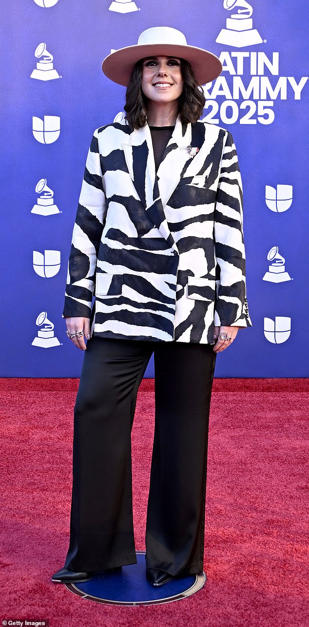 Throwback! Singer-songwriter Covi Quintana appeared in an oversized, zebra-print blazer jacket that looked more Y2K than 2025! Quintana paired the loud jacket with a pair of flowing black pants and an oversized, round-brimmed white hat with gold detailing around it. She finished the look off with a pair of pointed black boots
