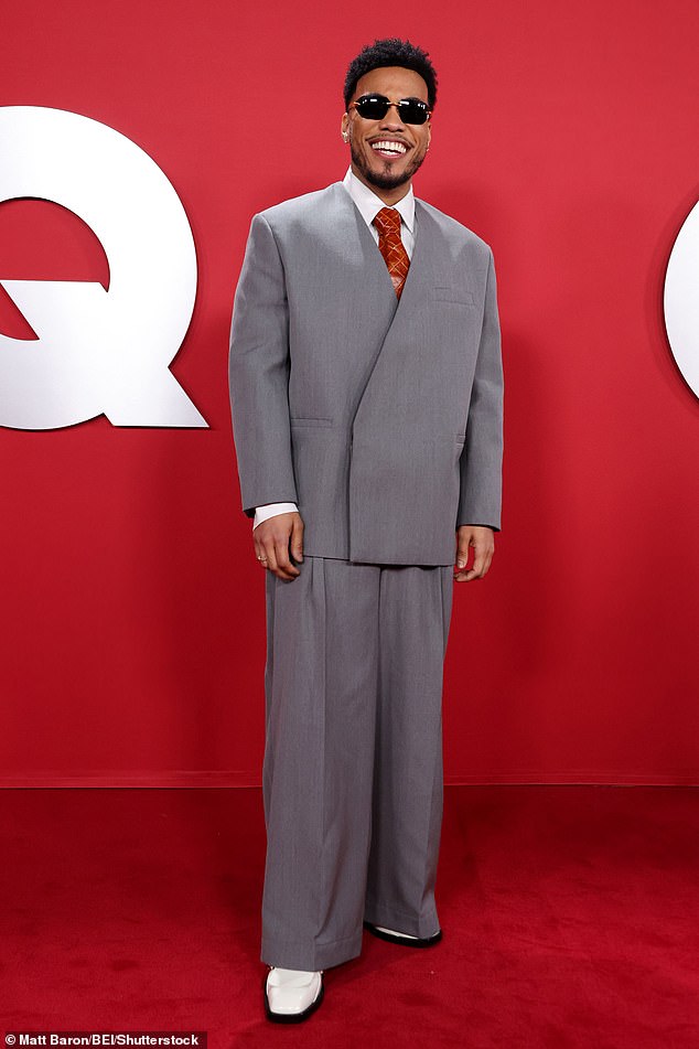 Cheers htimaker Anderson .Paak, 39, looked cool in a boxy grey suit paired with a red tie
