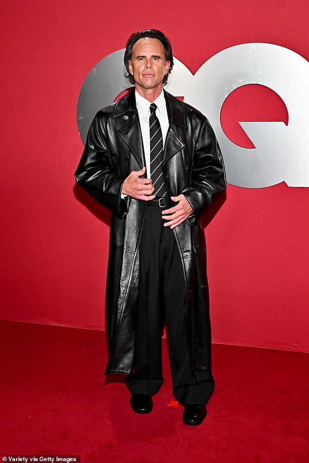 Walton Goggins, 54, cut a stylish figure in a black leather trench paired with a crisp white shirt and black wide-leg trousers