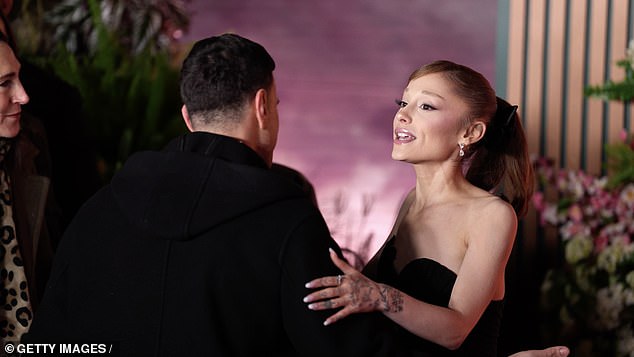 In a new clip, Grande can be seen posing up a storm for snappers shouting for her attention until both she and her co-star Cynthia Erivo flagged down a handler for help - days after the singer was attacked by a fan on the red carpet