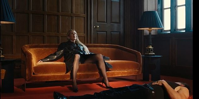 Minniear sprawls across the floor as Goulding reclines on a sofa in another scene