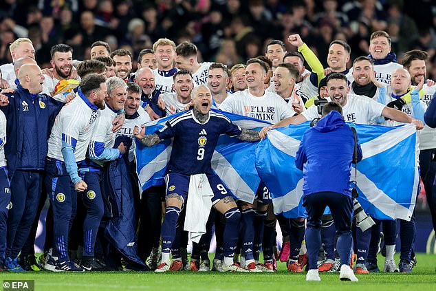 Clarke beams with delight in the middle of his squad and staff as Scotland celebrate an incredible triumph