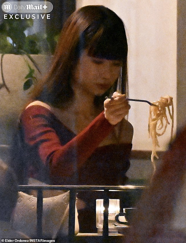 Exclusive images obtained by the Mail show Chung seated alone twirling pasta on her fork