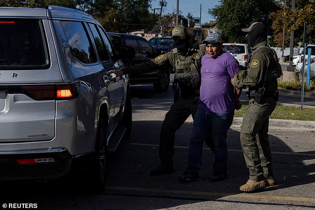 Pictured: Federal agents detain a man in the parking lot of a Home Depot in Chicago