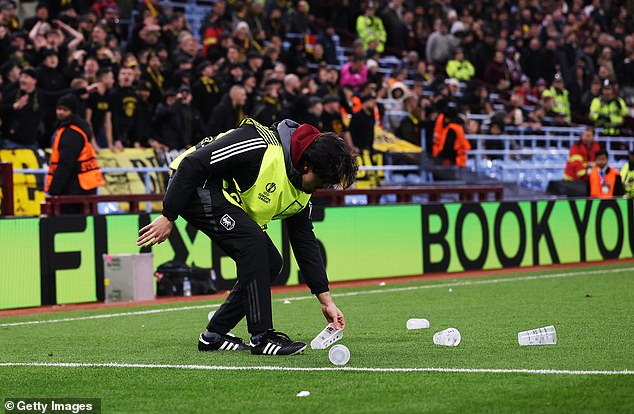 The pitch was littered with plastic cups thrown down by the visiting fans which forced a pause