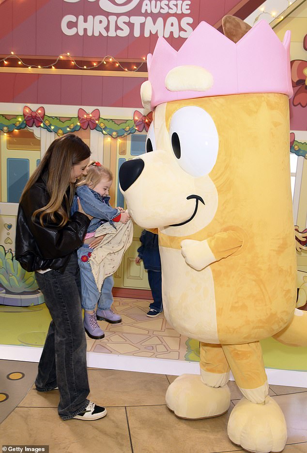 She was beaming from ear to ear as she lifted her daughter up to greet a Bluey mascot in a sweet moment