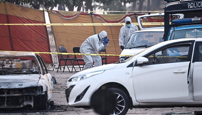Forensic experts examine a car after a suicide blast outside the district court in Islamabad on November 11, 2025. — AFP