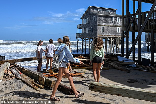 Locals check out which houses are still standing and which have been sucked away by the Atlantic following a series of rough storms