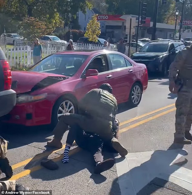 A female, who was driving the red car, is seen being held on the ground as one of her shoes came off her foot