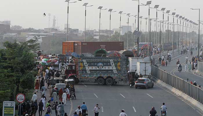 Trucks and containers block Ravi Bridge as supporters of Tehreek-e-Labbaik Pakistan (TLP) supporters march in Lahore, October 10, 2025. — Reuters