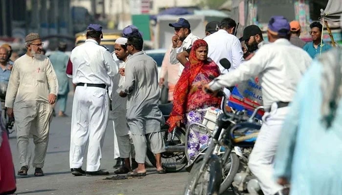 Traffic police officials charge a challan for violating the traffic rules at Saddar area in Karachi. — PPI