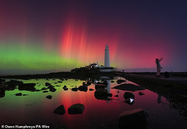 The Northern Lights glowing in the sky over St Mary's Lighthouse in Whitley Bay on the North East coast