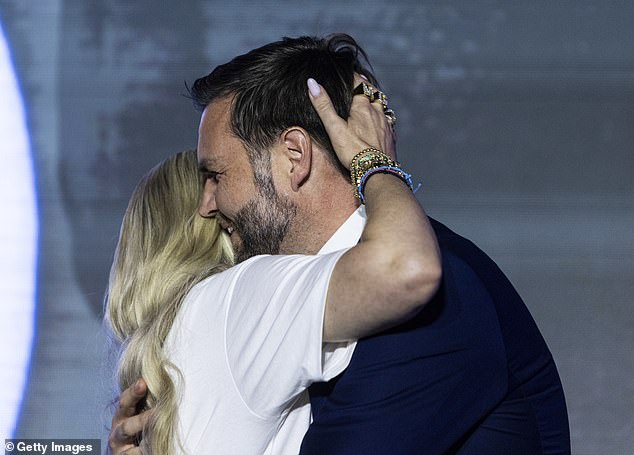 Erika Kirk, widow of Turning Point USA founder Charlie Kirk, and U.S. Vice President JD Vance embrace on stage