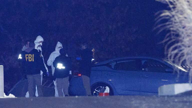 Investigators look at a grey Nissan car at a storage facility where Neves Valente was found dead. Pic: Reuters