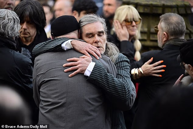 Stone Roses singer Ian Brown appeared emotional as he greeted fellow guests at the funeral