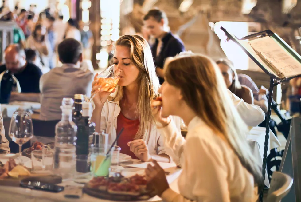 People eating and drinking wine in restaurant
