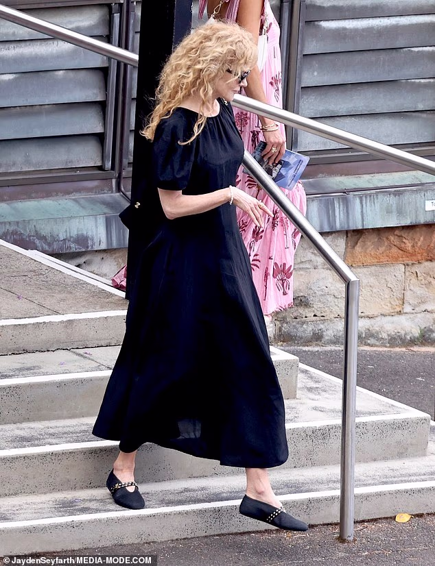 Nicole kept her head slightly bowed as she lingered outside the church, appearing deep in thought before making her way inside for the service