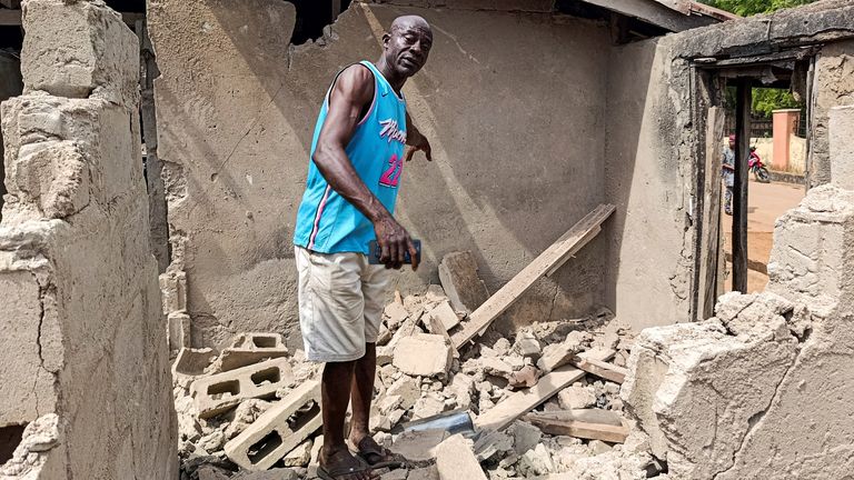 A man stands amid a destroyed building after US strikes in Offa, in the Kwara region. Pic: Reuters