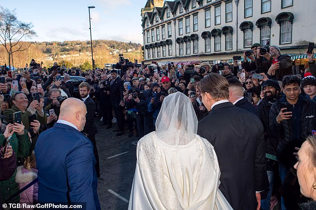 The happy couple were mobbed by well-wishers shouting 'Merry Christmas' as they passed