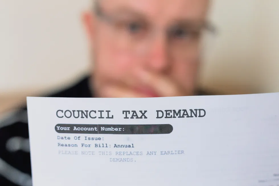 Council tax demand and person looks worried at it