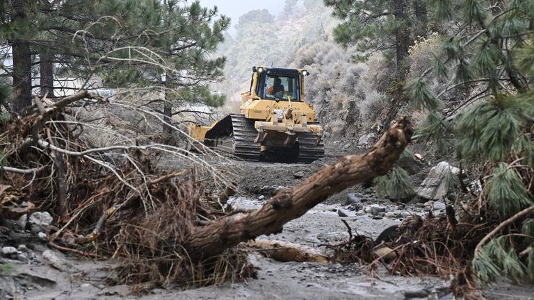 A tractor clears debris in Wrightwood, California.  Pic: AP/William Liang