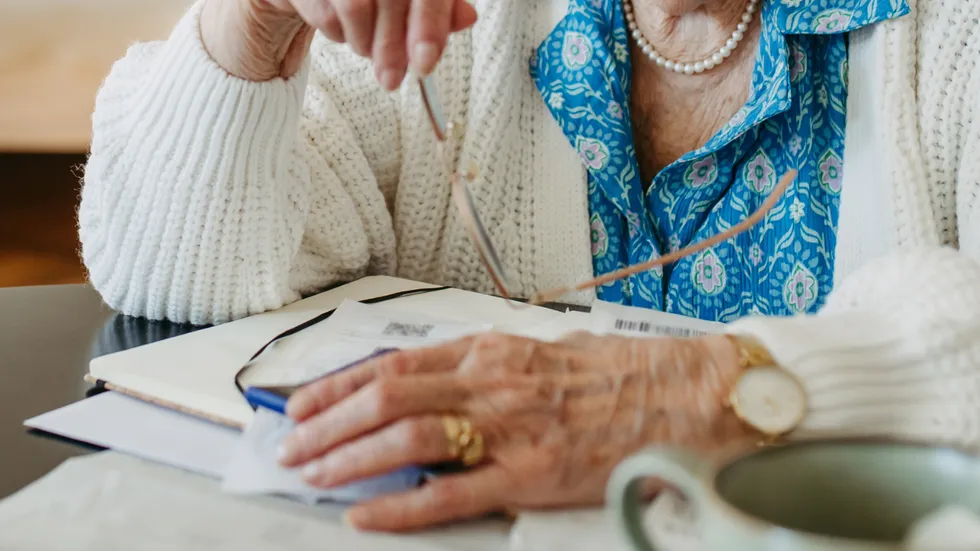 Stock image of an elderly woman reading documents