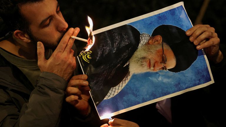 A protester burns a picture of Iran's Supreme Leader Ayatollah Ali Khamenei outside the Iranian embassy in London. Pic: Reuters.
