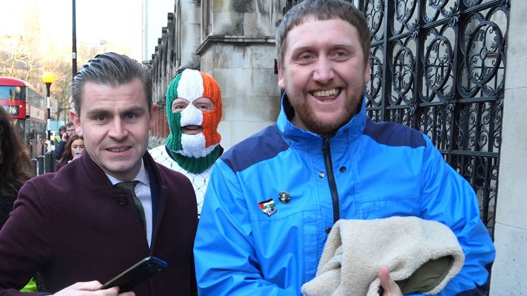 Darragh Mackin (left), a lawyer for the band, and manager Daniel Lambert (right), with DJ Provai outside the High Court. Pic: PA