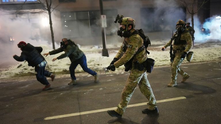 Federal agents try to clear demonstrators near a hotel in Minneapolis on 25 January. Pic: AP