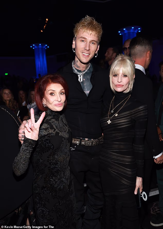 Sharon held up a peace sign for the snap as MGK, who rocked an all black ensemble, towered over her and daughter Kelly