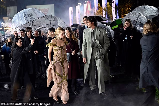 The actress and her leading man battled the rainy conditions as they arrived for the premiere