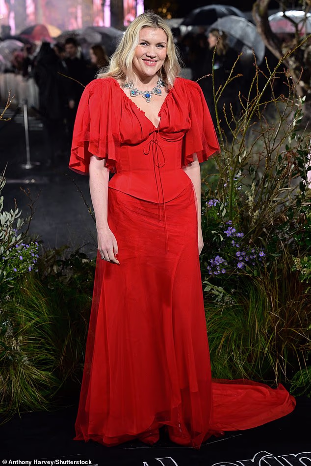 The beaming actress and writer stunned in the elegant red dress with a flowing train