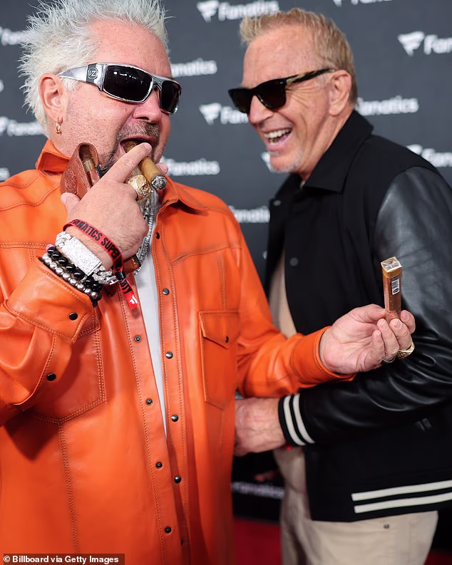 The 71-year-old Horizon filmmaker couldn't help but burst out laughing while posing with his eccentric chef pal, Guy Fieri, who was smoking a cigar on the red carpet