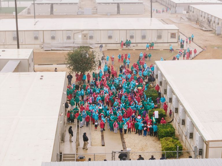 Detainees at the South Texas Family Residential Center in Dilley, Texas, wave signs during a demonstration. Pic: AP