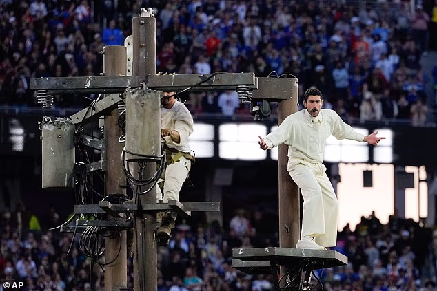 In one bizarre section of the performance, the headliner climbed a platform and was surrounded by dancers dressed like workers who dangled from wires as if they were repairing transformers on electrical poles