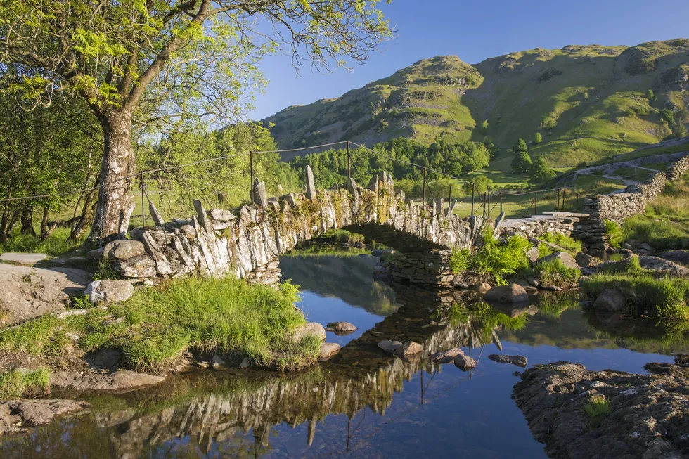 \u200bSlater's Bridge reflected in the tranquil waters of the River Brathay (file pic)