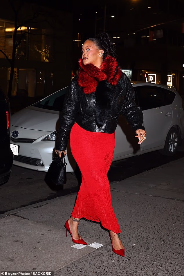 She completed her ensemble with a red and black fur scarf and slicked her raven tresses back into a high ponytail
