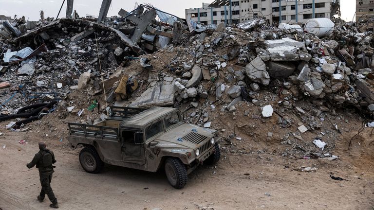 An Israeli soldier walks past a military vehicle in the southern Gaza Strip in December. Pic: Reuters