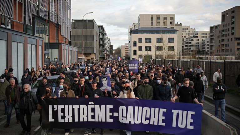 People hold a banner reading 'Far left kills' at Saturday's march. Pic: AP