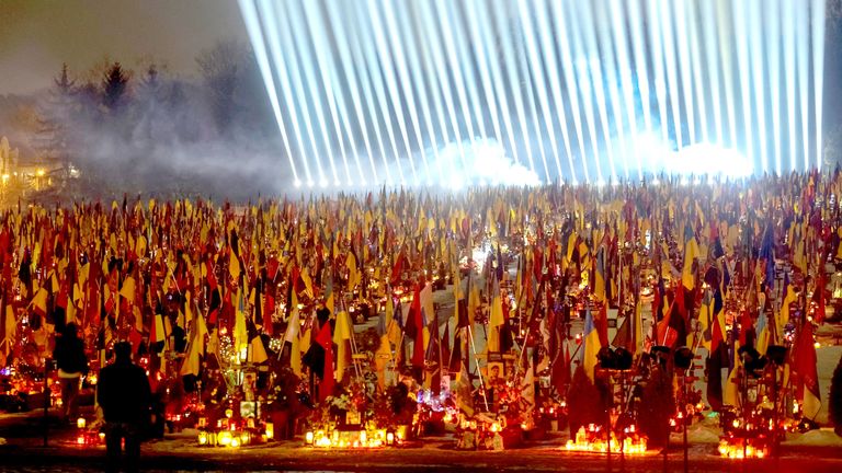 Ukrainians visiting the graves of their relatives in Lviv, western Ukraine. Pic: Reuters