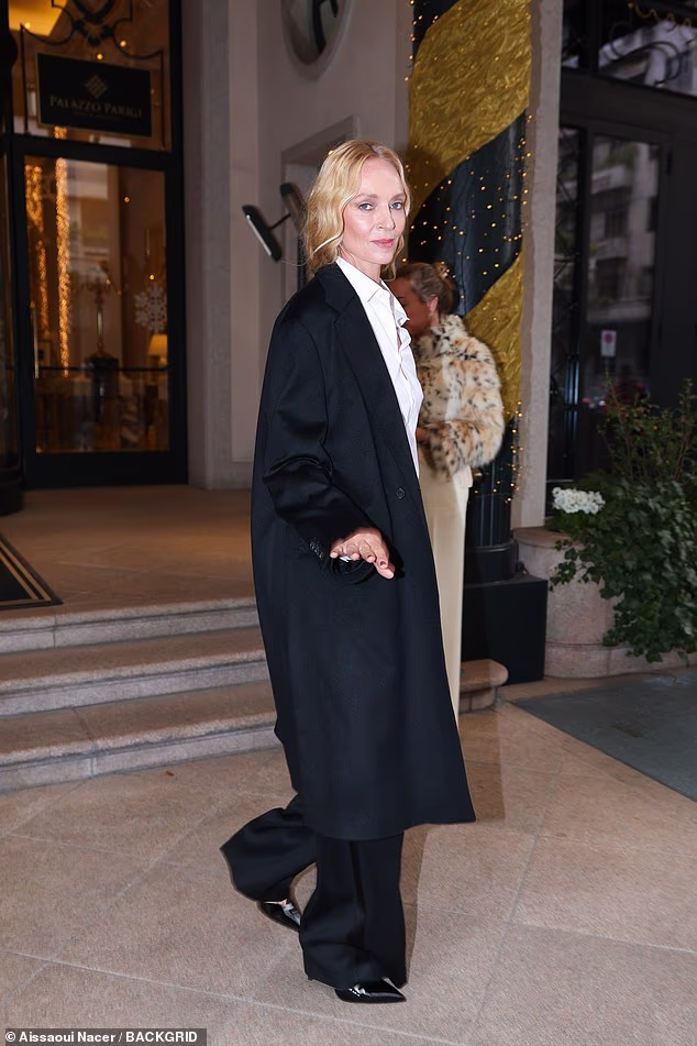 Uma Thurman opted for a flowing black coat with matching trousers and a white shirt as she made her way to the Fendi show