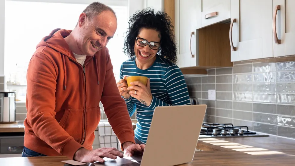 Couple look happy at laptop
