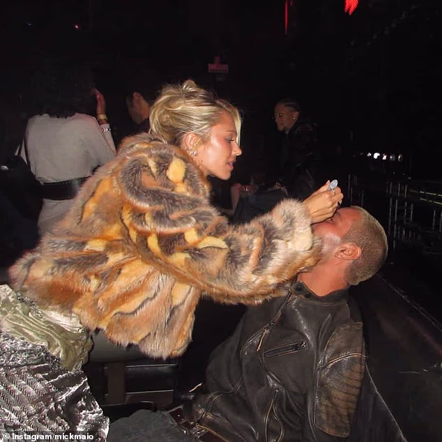 Mick  uploaded a candid snap taken in Los Angeles that shows Delilah leaning over Mick as he sits back on a lounge, dressed in a black leather jacket