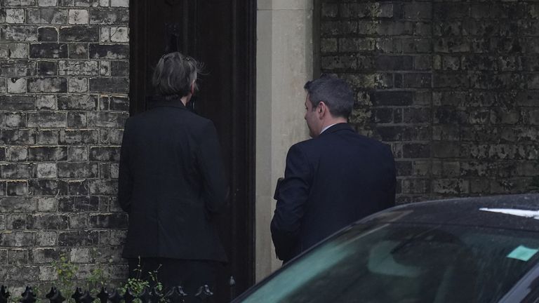 Two people wait to enter an address in north London. Pic: PA