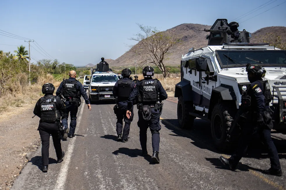 Members of the Civil Guard of Michoacan patrol a highway supported by armoured vehicles after a wave of violence in the town of Aguililla