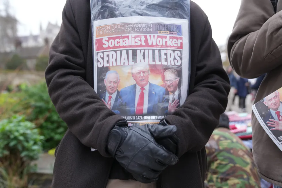 A person with a copy of the Socialist Worker during a protest